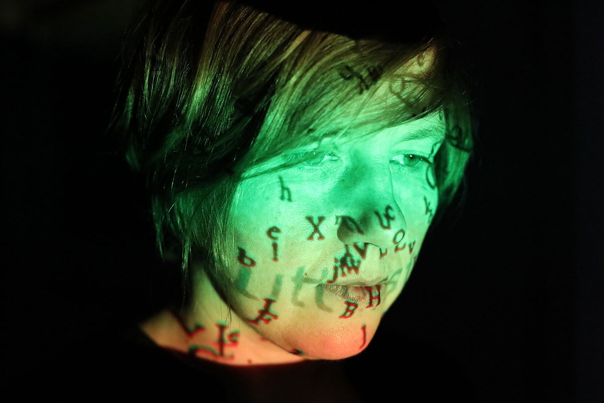 Portrait von Masha Qrella mit Projektion im Gesicht
