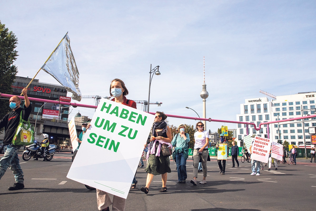 "Haben um zu sein" steht auf dem Schild einer Teilnehmerin einer Demonstration für das bedingungslose Grundeinkommen in Berlin