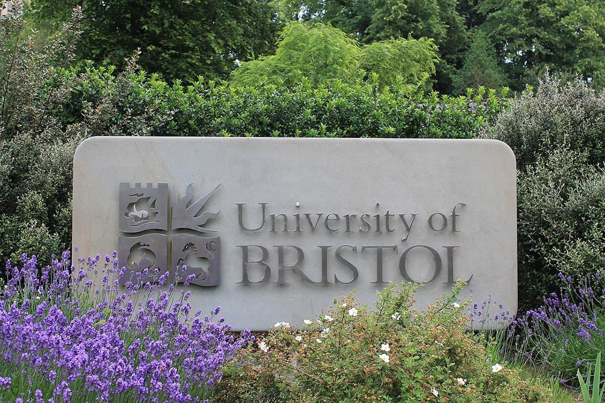 Stein mit Logo der University of Bristol umgeben von Pflanzen