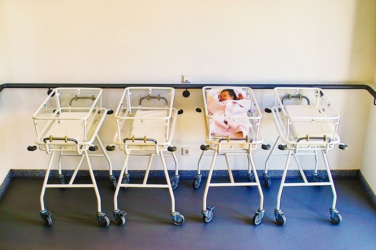 Vier Krankenhausbetten mit einem Neugeborenem