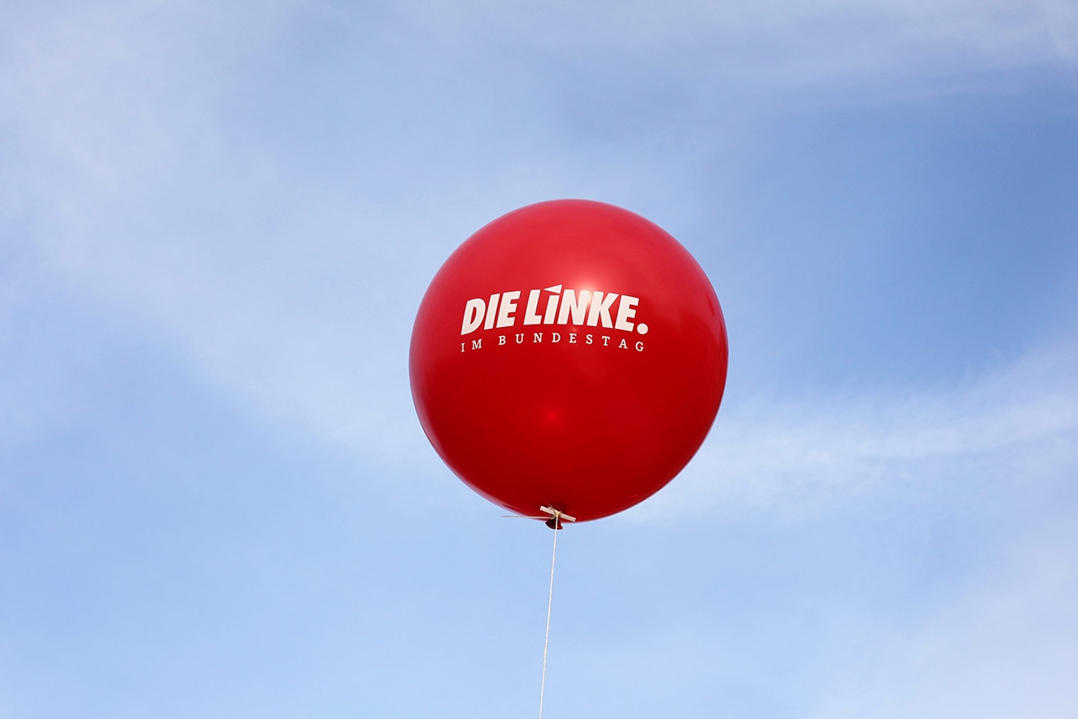 Roter Luftballon "Die Linke" am Himmel