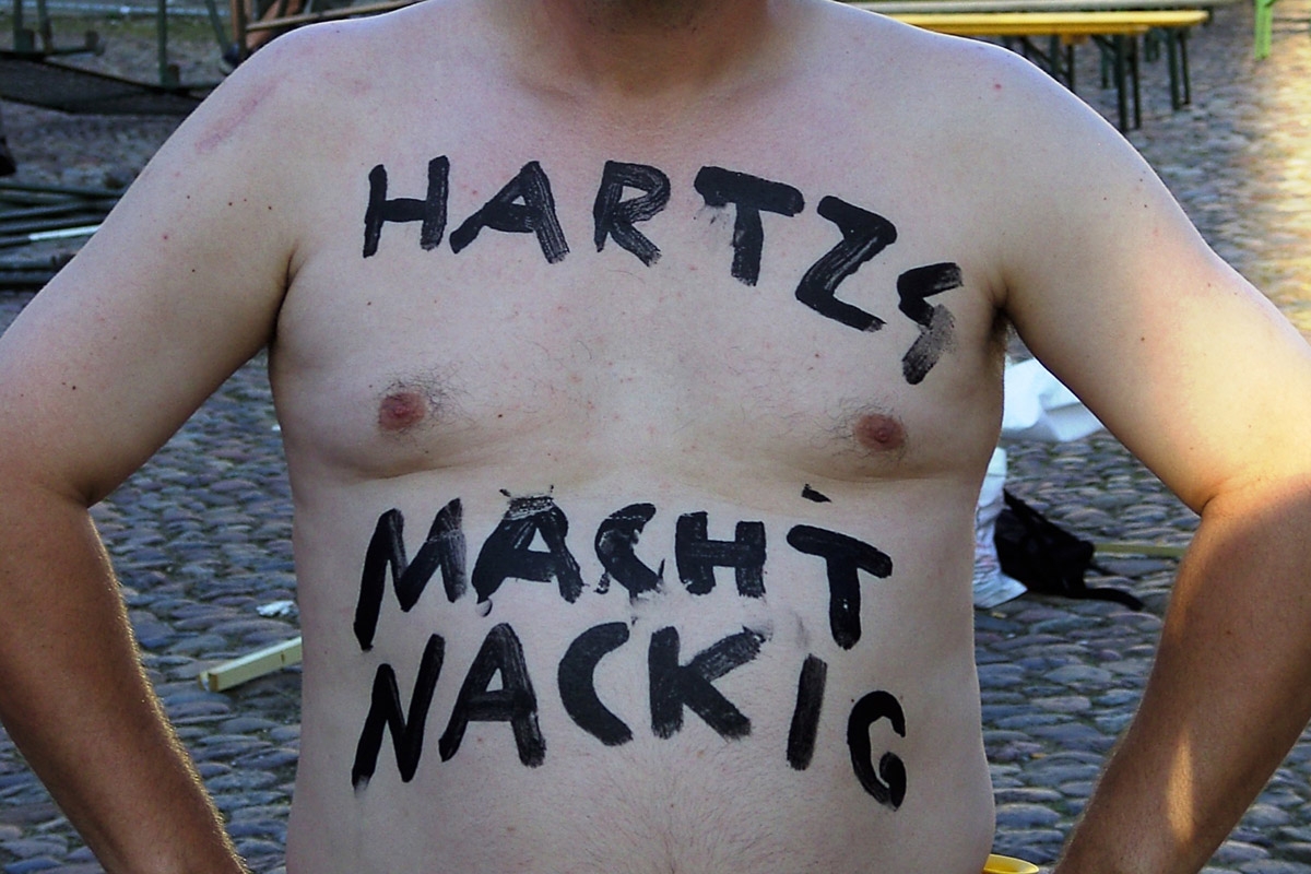 "Hartz 4 macht nackig" steht auf einem freien Oberkörper