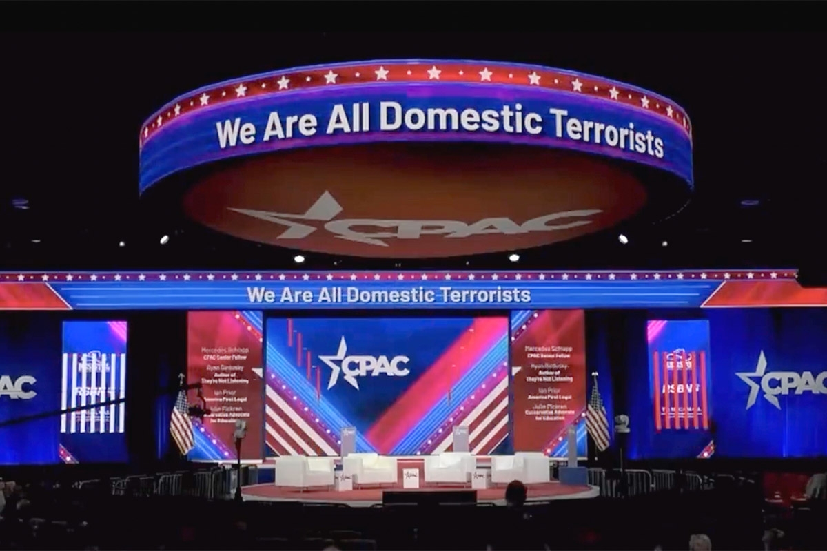 Bühne bei einem Treffen der CPAC mit dem Lichtschriftzug We are all Domestic Terrorists