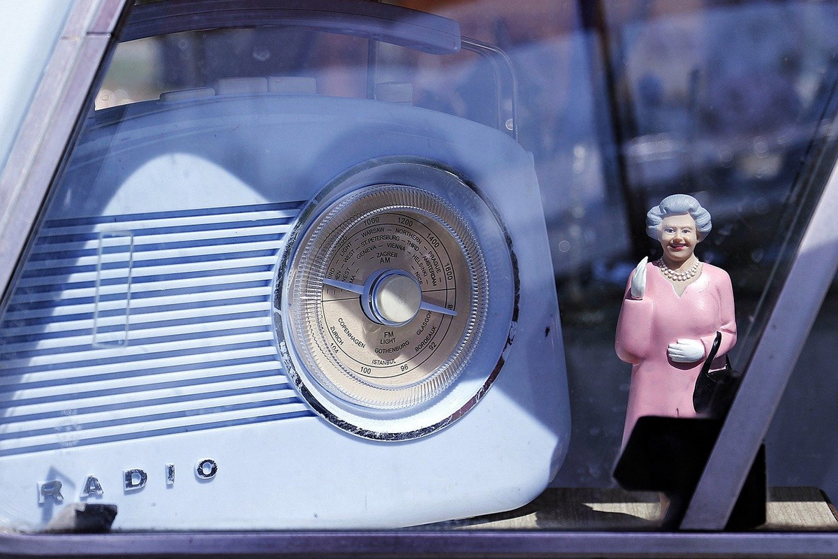 Figur der Queen neben einem antiken Radio in einem Auto