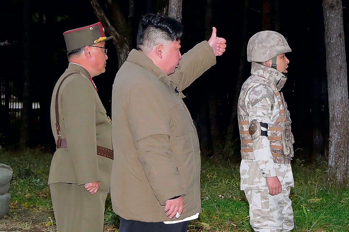 Kim Jong-un mit zwei Soldaten zeigt seinen Daumen