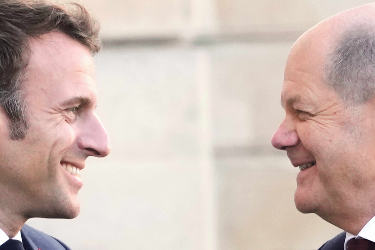Emmanuel Macron und Olaf Scholz lächeln einander an
