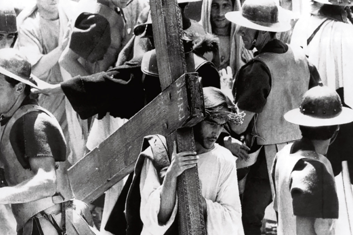 Filmbild in Schwarzweiß: Jesus trägt ein Kreuz