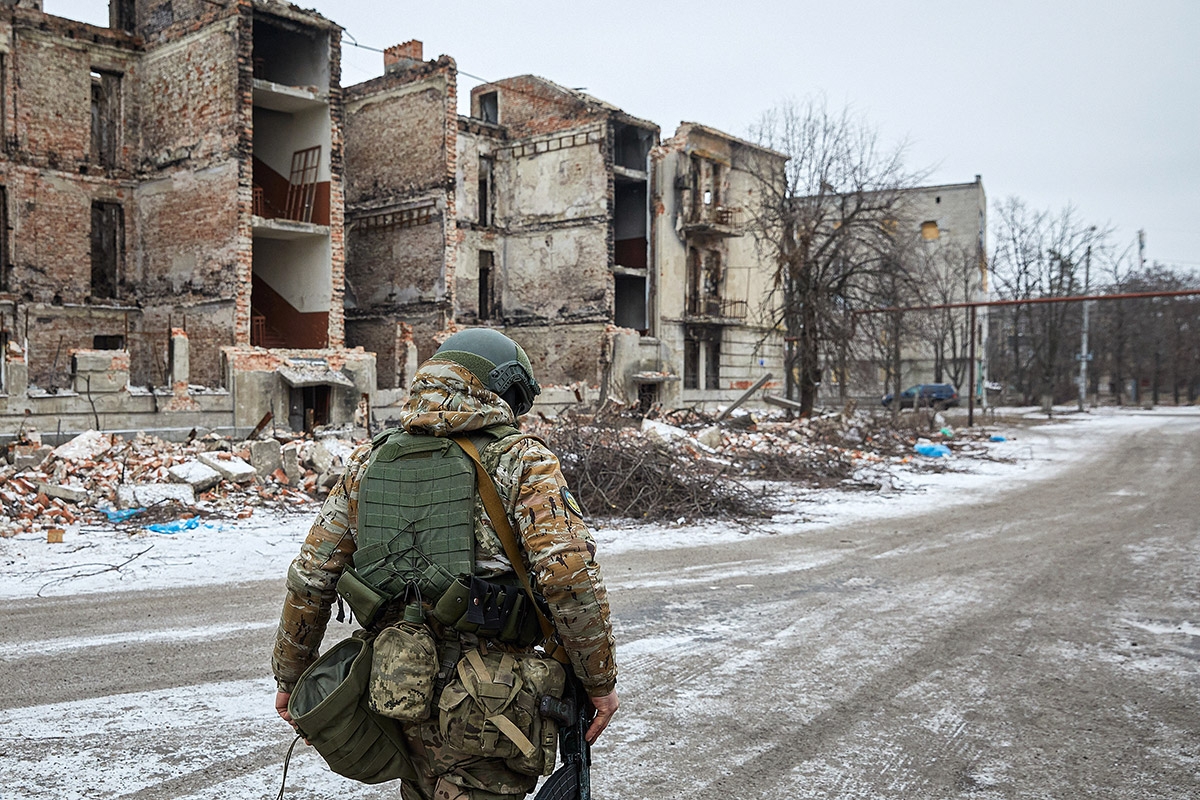 Ein Soldat vor einer ausgebombten Häuserreihe