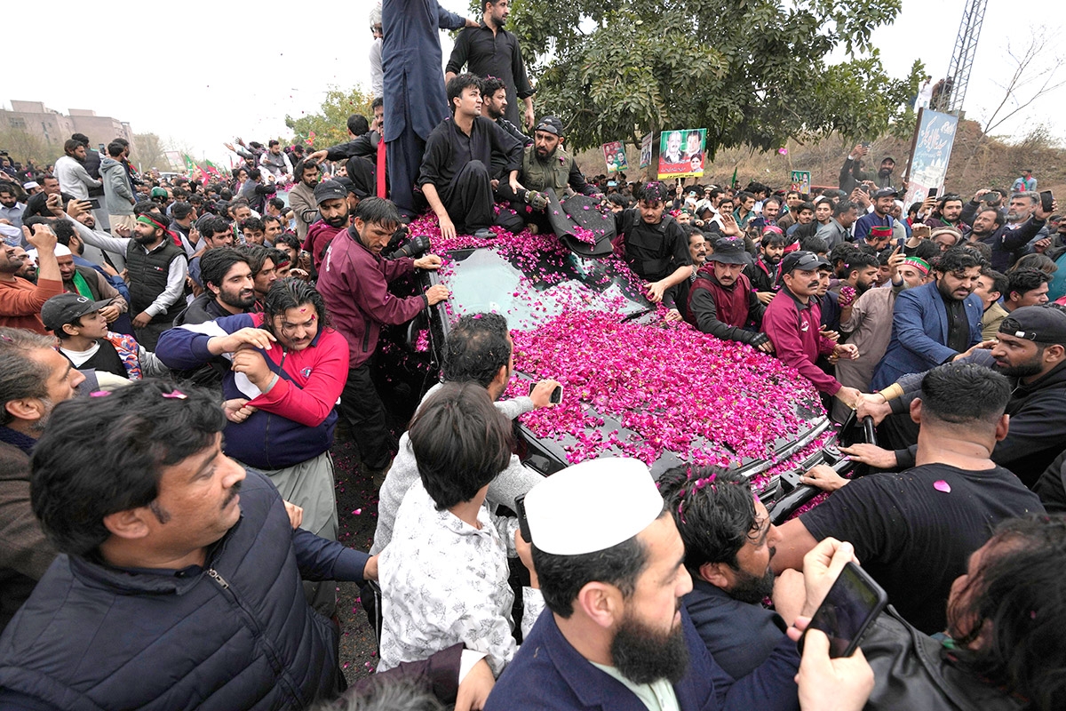 Ein mit Blumen übersähtes Auto inmitten einer Menschenmenge