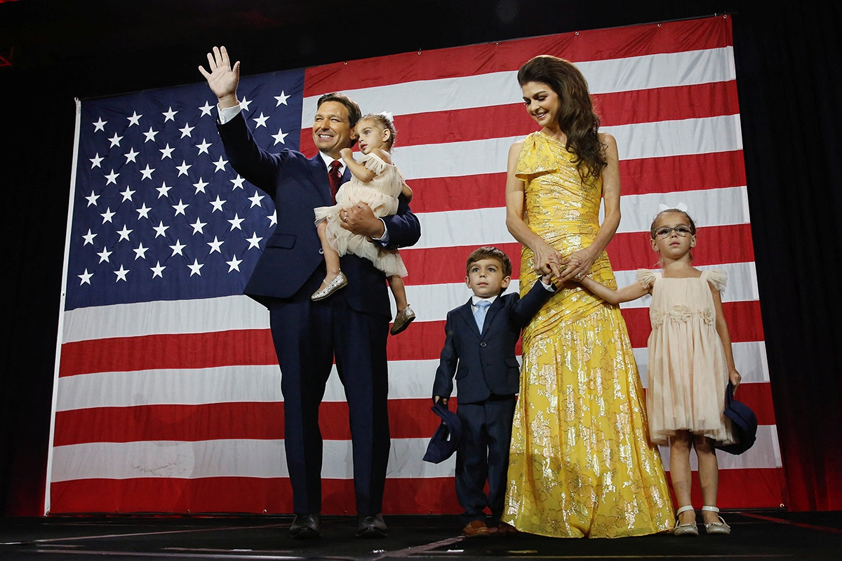 Ron DeSantis winkend mit Ehefrau und Kindern vor USA-Flagge