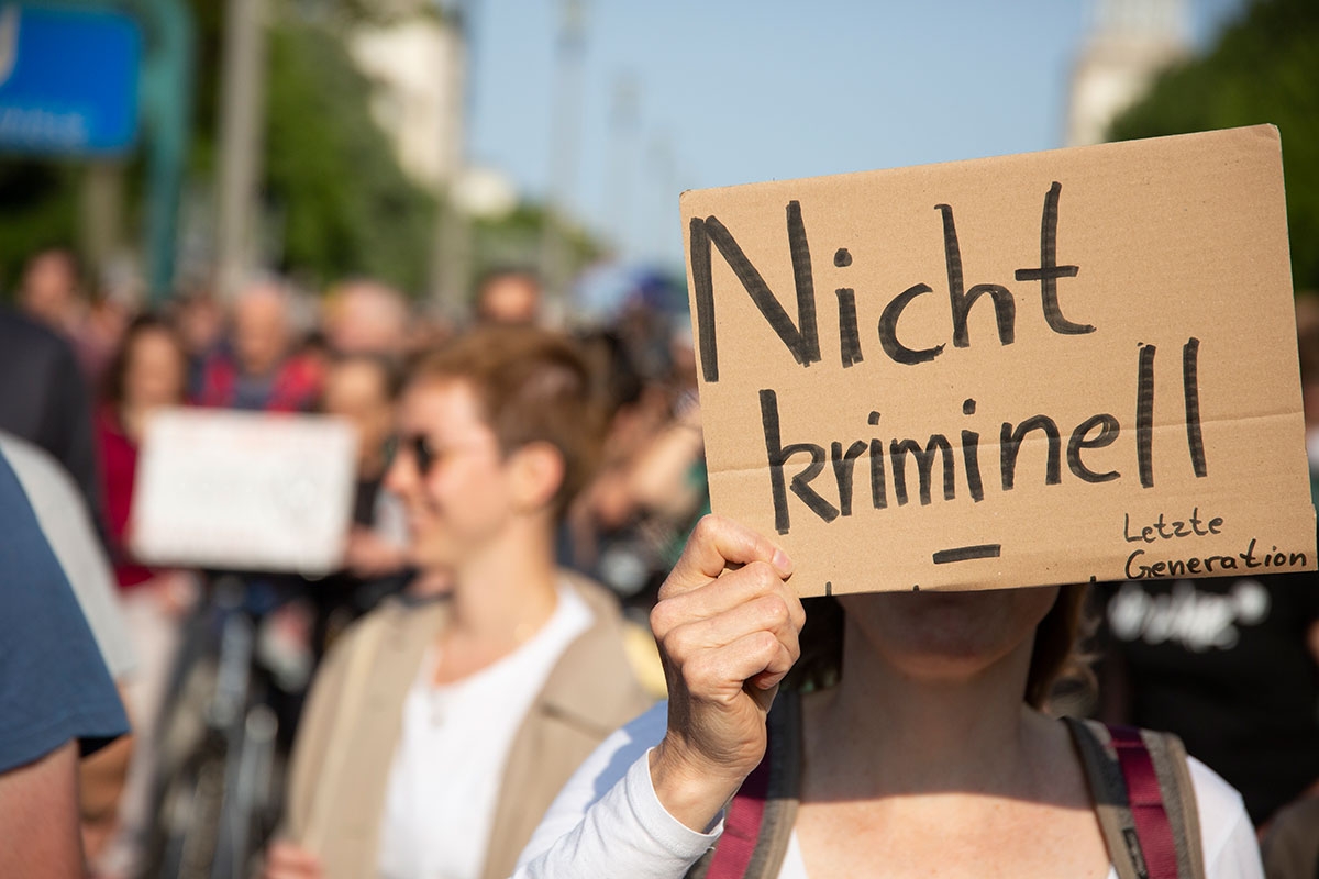 Handgemaltes Schild mit der Aufschrift "nicht kriminell" bei einer Demo der Unterstützer der Klimaaktivisten von Letzte Generation