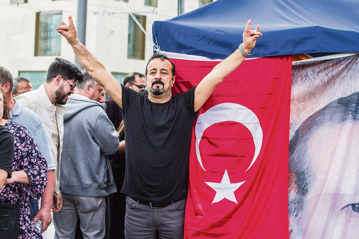Vor einer Wahlstelle für die türkische Präsidentschaftswahl in München zeigt ein Anhänger Recep Tayyip Erdoğans das Zeichen der »Grauen Wölfe«