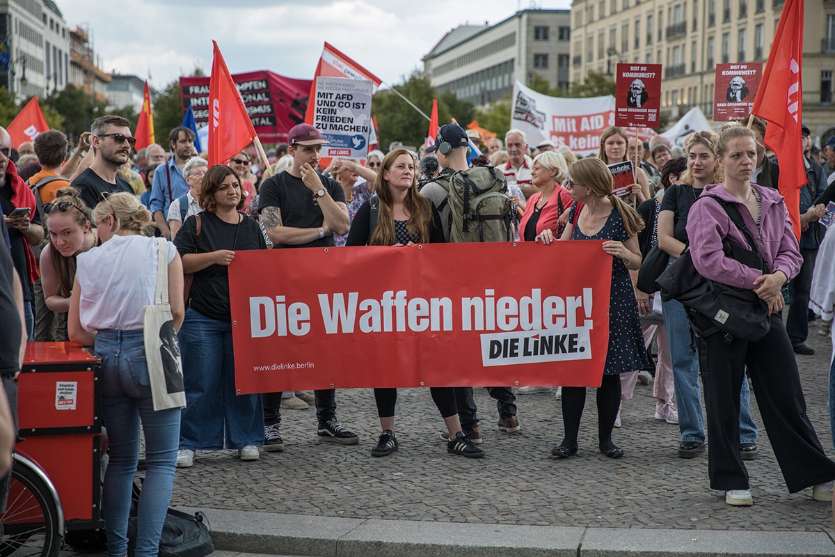Janine Wissler, Bundesvorsitzende der Linkspartei, hinter Linkspartei-Transparent: »Die Waffen nieder!«