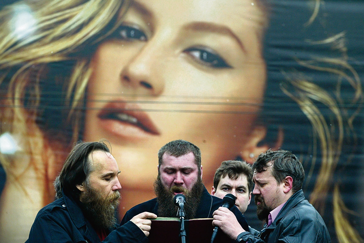 Aleksandr Dugin (l.) und Mitstreiter auf einer Veranstaltung in Moskau, 8. April 2007, im Hintergrund Werbung mit Gisele Bündchen