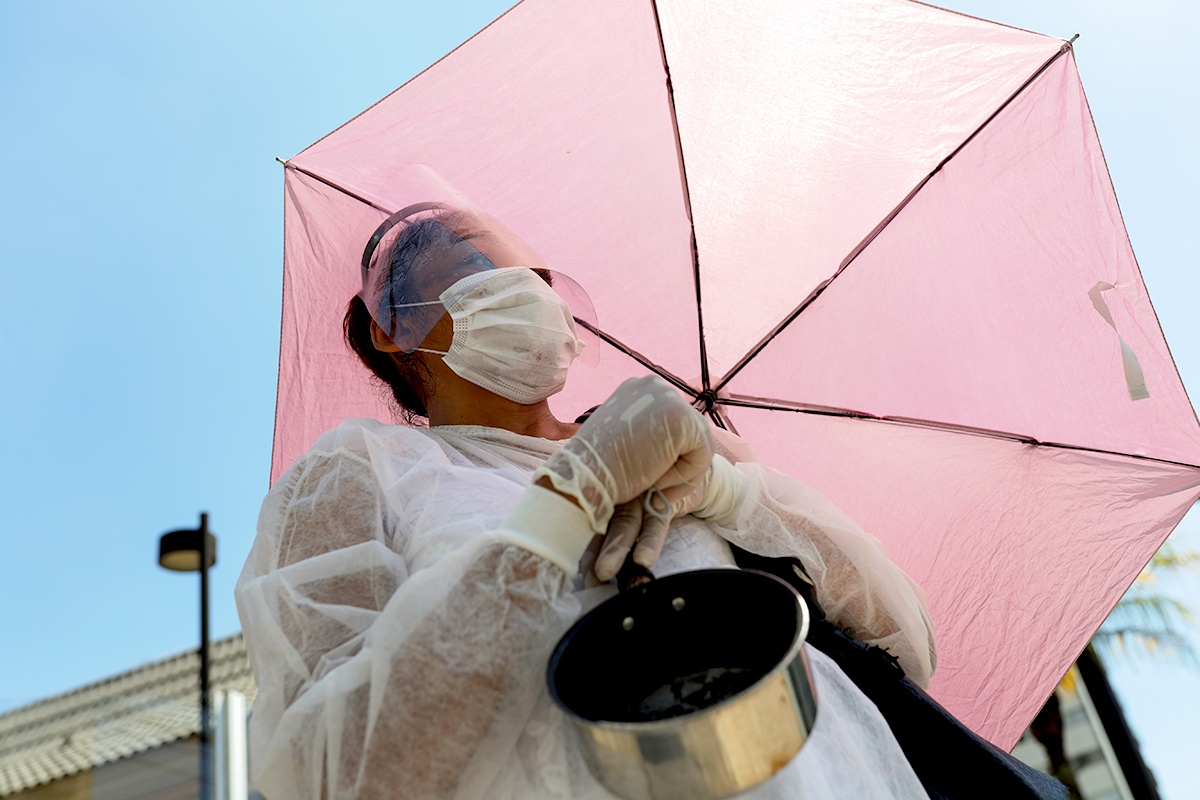 Eine Frau mit Schirm demonstriert in São Paulo (Brasilien) gegen Hunger in der Covid-19-Pandemie, 26. März