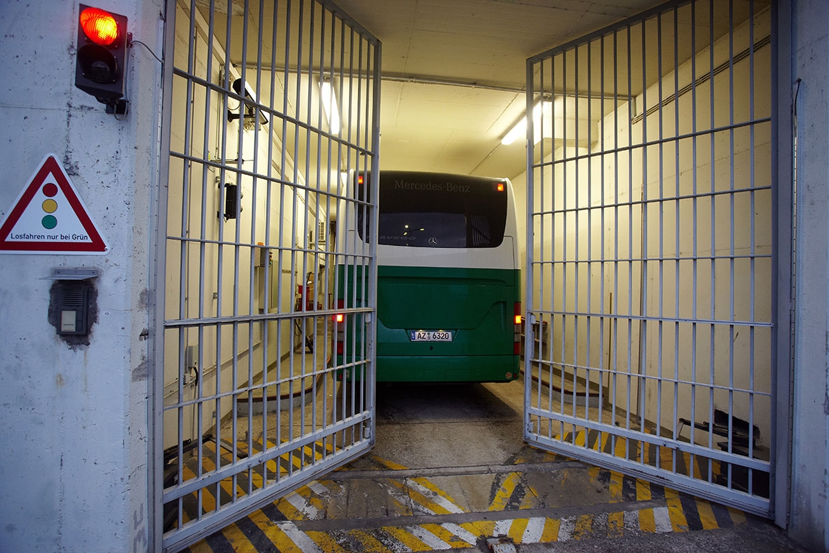 Bus hinter sich schließendem Gefängnistor