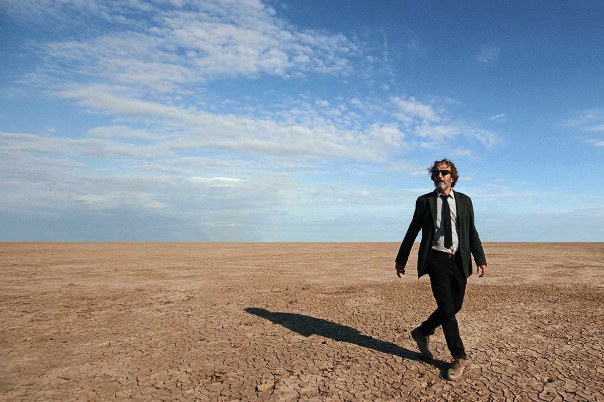 Ein Mann im Anzug geht durch die Wüste