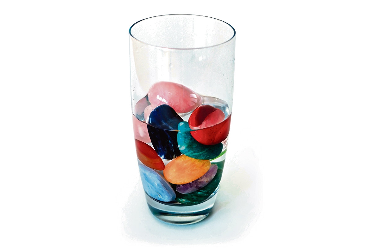 Ein Glas mit Wasser und bunten Steinen darin