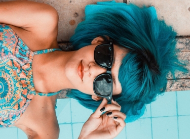 Frau mit blauen Haaren am Pool