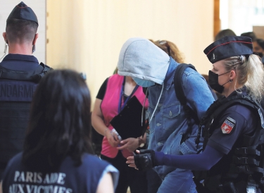 Einer der Angeklagten wird in den Gerichtssaal im Palais de Justice in Paris geführt