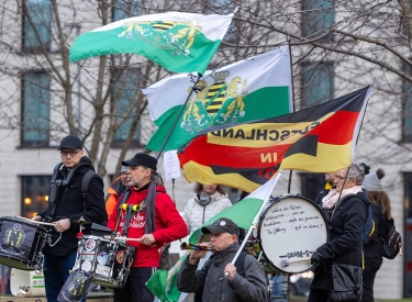 Stets weiß-grün beflaggt unterwegs. Anhänger der Freien Sachsen protestieren im Februar bei einem Besuch des Bundeskanzlers in Dresden