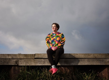 Katharina Volckmer sitzt vor grauen Wolken