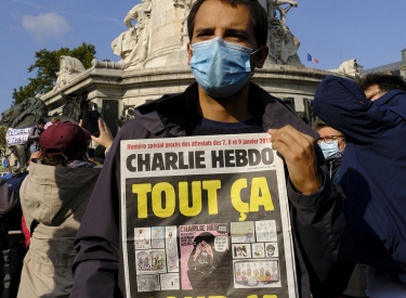 Demonstrant mit einer Ausgabe der Wochenzeitung Charlie Hebdo