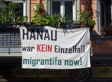 Plakat an einem Berliner Haus mit dem Text "Hanau war kein Einzelfall migrantifa jetzt"