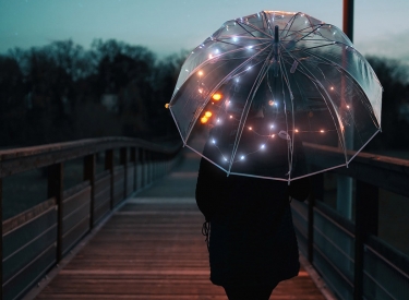 Spazierende von hinten fotografiert mit transparentem Regenschirm