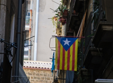 Katalanische Fahne hängt in einer Gasse vom Balkon