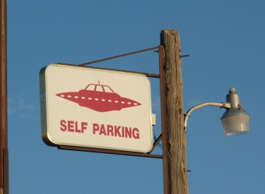 Schild mit Aufschrift: "Self Parking" und dem Bild eines Ufo