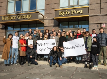 Gruppenfoto von Mitarbeitenden der Kyiv Post mit Schildern: "We are the Kyiv Post" und "Save the Kyiv Post"