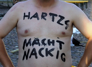 "Hartz 4 macht nackig" steht auf einem freien Oberkörper