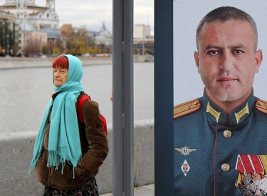Passantin vor einem Plakat eines russischen Soldaten im Zentrum Moskaus