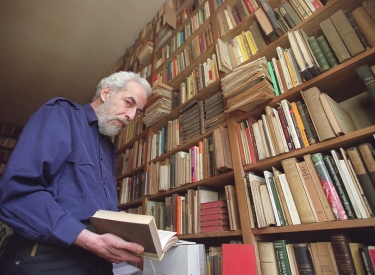 Thomas Kuczynski zu Hause, vor einem riesigen Bücherregal