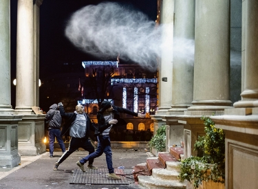 Demonstranten werfen Steine auf Polizeibeamte, die die Tür des Rathauses in Belgrad bewachen, 24. Dezember