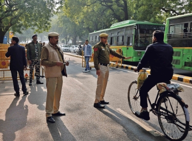Erhöhte Sicherheitsvorkehrungen. Ein Polizist hält einen Radfahrer vor dem Parlamentsgebäude in Neu-Delhi an, 13. Dezember