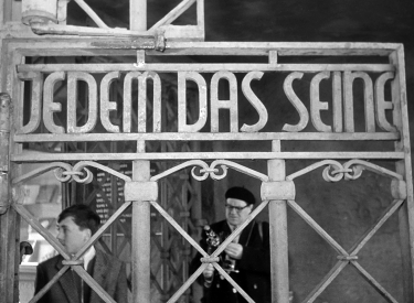 Besucher des KZ Buchenwald am Tor des Lagers mit dem Schriftzug »Jedem das Seine«, 1960