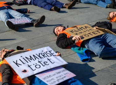Aktivistinnen der Letzten Generation am Frauentag vor dem Bundeskanzleramt, um auf die übermäßige Betroffenheit von Frauen in der Klimakrise hinzuweisen. Auf den Schildern steht "Klimakrise tötet"